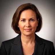Valeshka Cartiera with a calm studio portrait and dark blazer